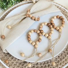 a white plate topped with wooden beads next to a napkin on top of a table