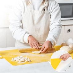 a woman in an apron is making food on a cutting board and rolling out the dough