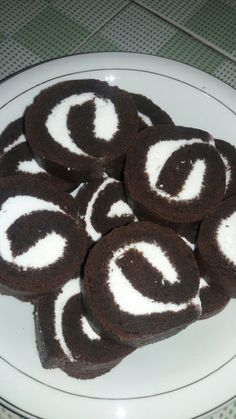 a white plate topped with chocolate cookies covered in frosting on top of a table