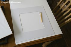 a white box with a pen on top of it sitting next to a wooden chair