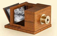 an old fashioned wooden box with two pictures in it and a lock on the inside