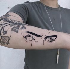 a man's arm with an evil face tattoo on it