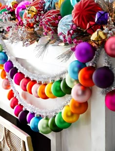 an assortment of colorful ornaments are hanging on the fireplace mantel, decorated with beads and tinsel