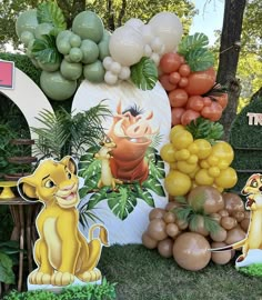 the lion king birthday party is complete with balloons, fruit and paper cutout animals