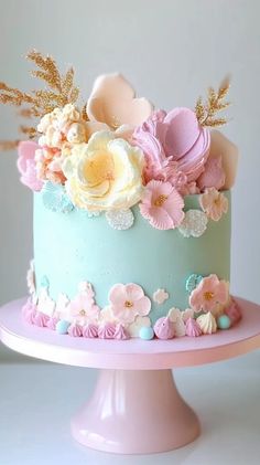 a blue cake with pink and white flowers on top