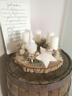 a wooden table topped with candles next to a white sign and some decorations on top of it