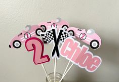 a vase filled with pink and black cupcake toppers