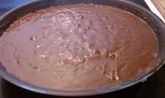 a pan filled with chocolate sitting on top of a stove