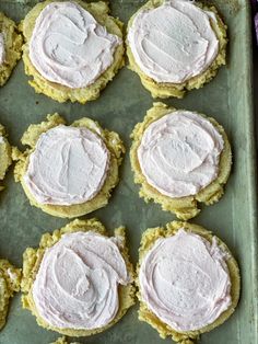 there are many cookies with frosting on the cookie sheet