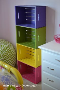 a stack of colorful boxes sitting on top of a white dresser