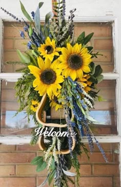 sunflowers and greenery decorate the welcome sign in front of an old window