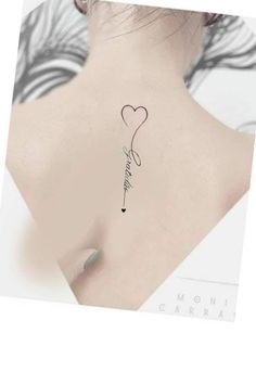 the back of a woman's neck with a heart tattoo on it