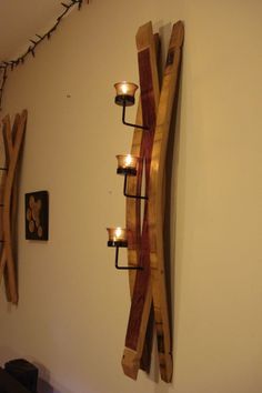 a candle holder made out of wooden sleds with candles on the wall next to it