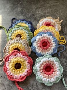 four crocheted flowers are sitting on the ground