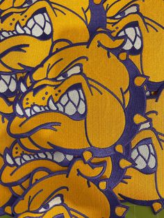 an image of a group of yellow and purple bulldogs on a green background with the words lsu written in large white letters