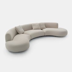 a curved couch with pillows on it