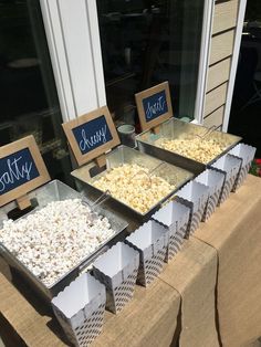 three trays filled with popcorn sitting on top of a table next to each other