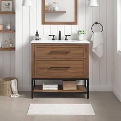 a bathroom vanity with two drawers and a mirror above it, along with other items