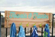 towels are hanging on a fence near a sign