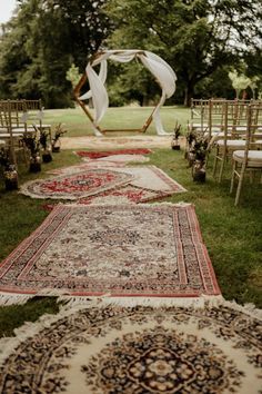 an outdoor ceremony with rugs and chairs