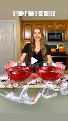 a woman sitting at a kitchen counter with two glasses in front of her and the words spooky hand ice cubes