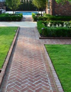 an image of a brick walkway in the middle of a yard with grass and bushes