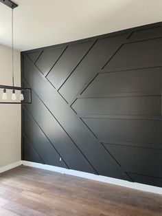 an empty room with black painted walls and wood floors