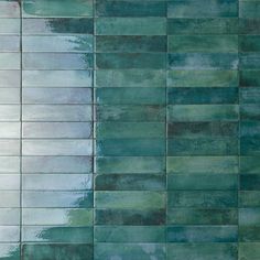 a tile wall with green and blue tiles on the bottom, in an abstract pattern