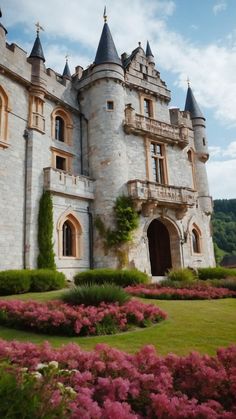 a large castle like building surrounded by flowers