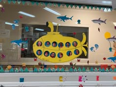 there is a yellow submarine with pictures on the front and sides in this window display