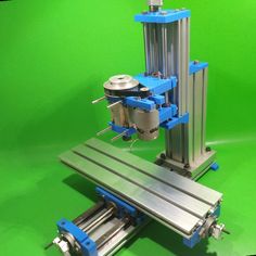 a machine that is sitting on top of a green surface with blue trimmings