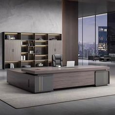 an office desk in the middle of a room with large windows and bookcases