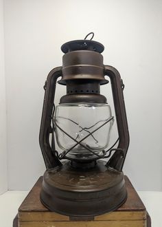 an old fashioned lantern sitting on top of a wooden box