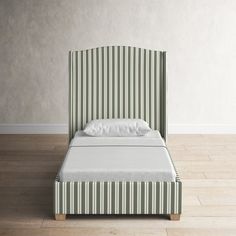 a bed with a green and white striped headboard