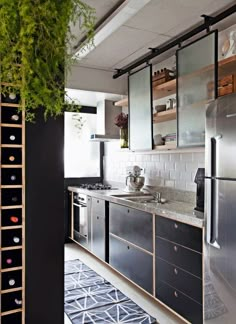 an instagramted photo of a kitchen with black cabinets and stainless steel appliances in it