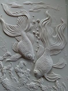 two white fish are on the wall