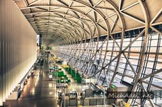 the inside of an airport terminal with lots of windows and metal bars on each side