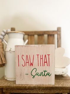 a wooden sign that says i saw that santa is on top of a table with other items