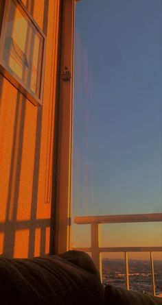 the sun is shining on an ocean view from a balcony with a window that looks out onto the water