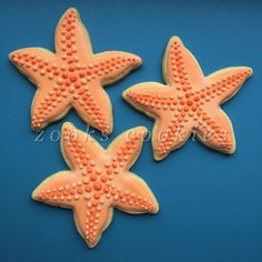 three decorated starfish cookies on a blue background