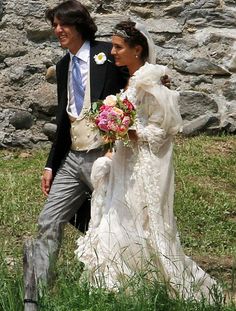 the bride and groom are walking together outside