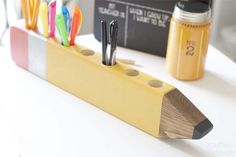 a pencil holder with pens and markers on it