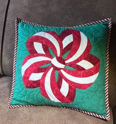 a green and red pillow sitting on top of a couch