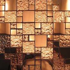 a close up view of a wall made out of glass tiles with gold foiling on it