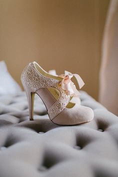 a pair of high heeled shoes sitting on top of a bed