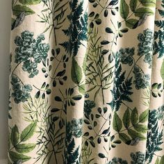 a curtain with green leaves and flowers on it