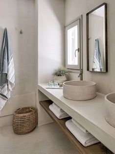 a white bathroom with two sinks and towels on the counter next to eachother