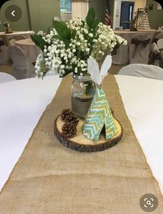 a vase filled with flowers sitting on top of a wooden slice next to a table