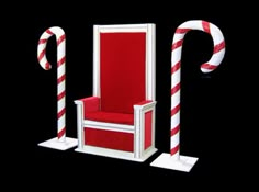 a red and white chair sitting on top of a black floor next to candy canes