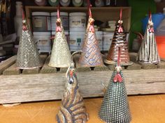 several small metal bells are on display in a store shelf with other items behind them